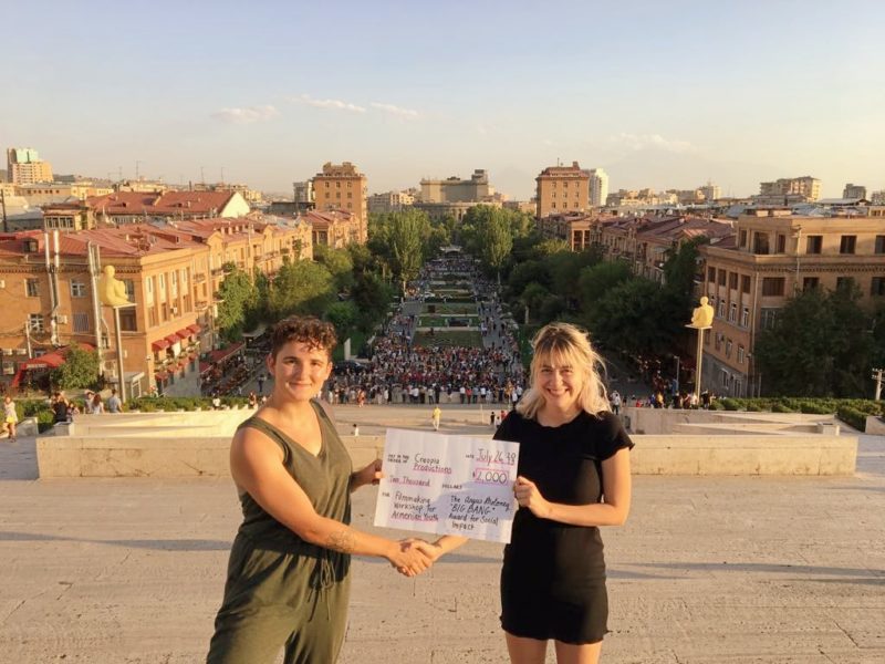 Grant recipient Sashka Avanyan receiving a $2,000 check from Camille Babington, co-founder of Stardust Startups, in Armenia.