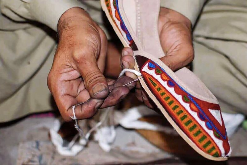 Pakistani artisan embroidering shoes