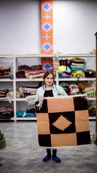 Yezidi Rug Factory Woman holding rug