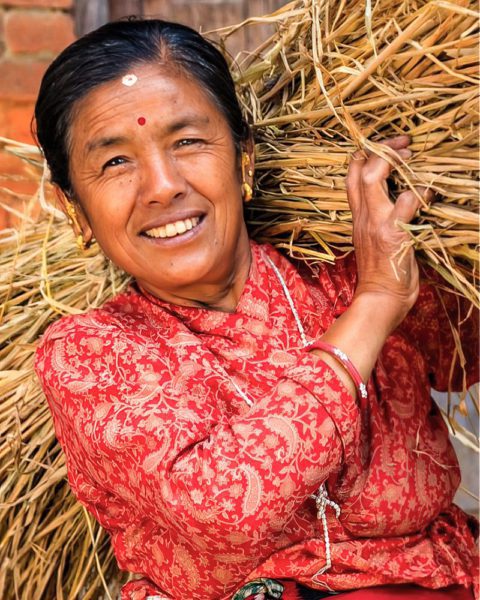 Asian woman carrying hay