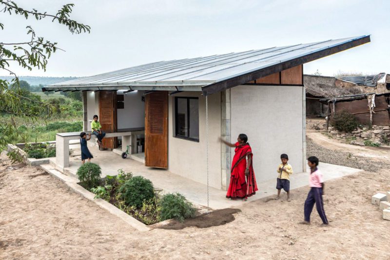 Asian family next to house with solar panelled roof