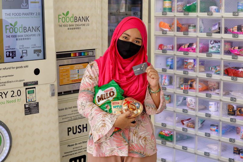 Asian woman in front of food bank vending machine