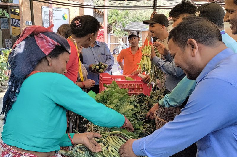 Farmers sell vegetables to local customers at a community event