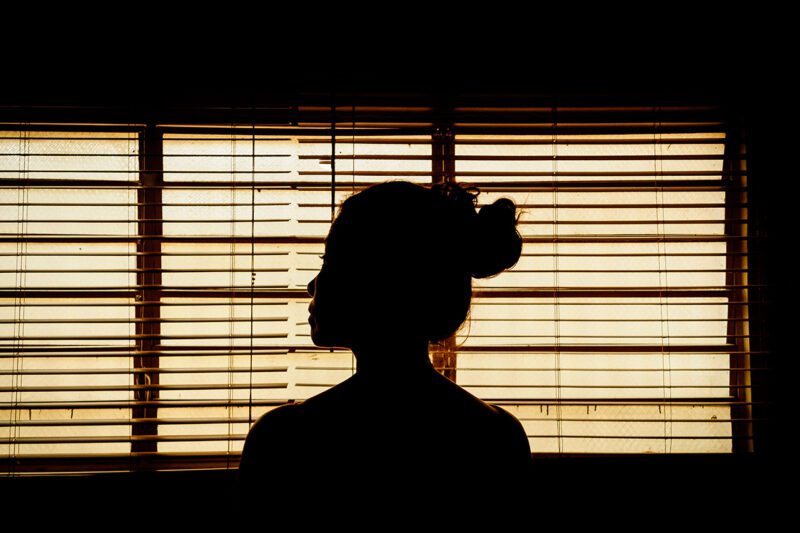 Black female in front of window shade