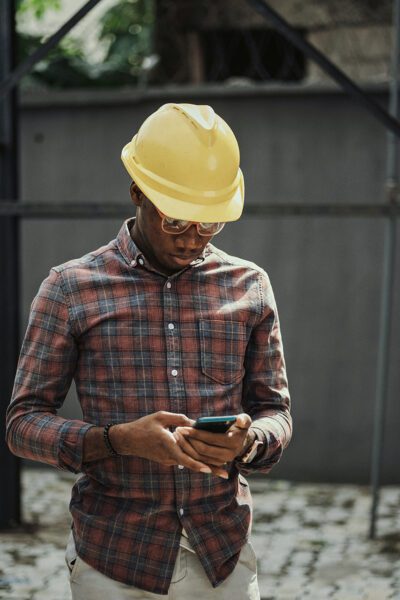 African hard hat worker on cell phone