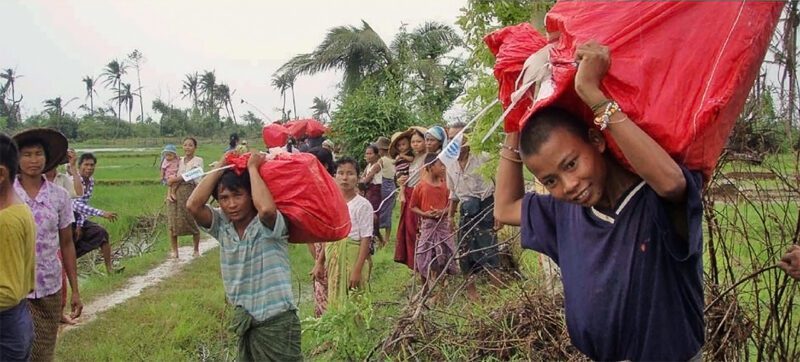 Children carrying red sacks in Myanmar