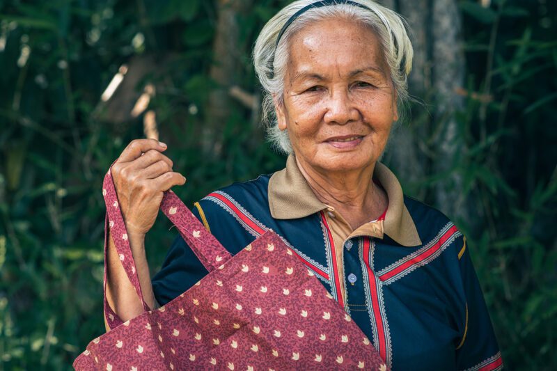 Asian woman holding handwoven bag