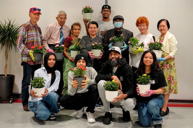 Group of people holding potted plants