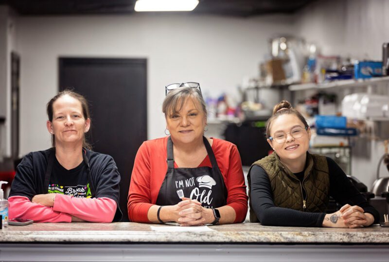 Three women sitting at table in work setting