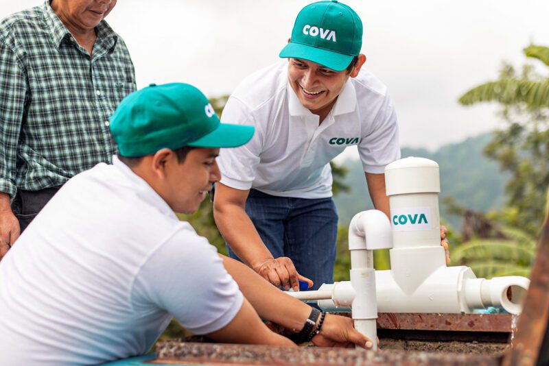 Employees wearing green caps collaborating