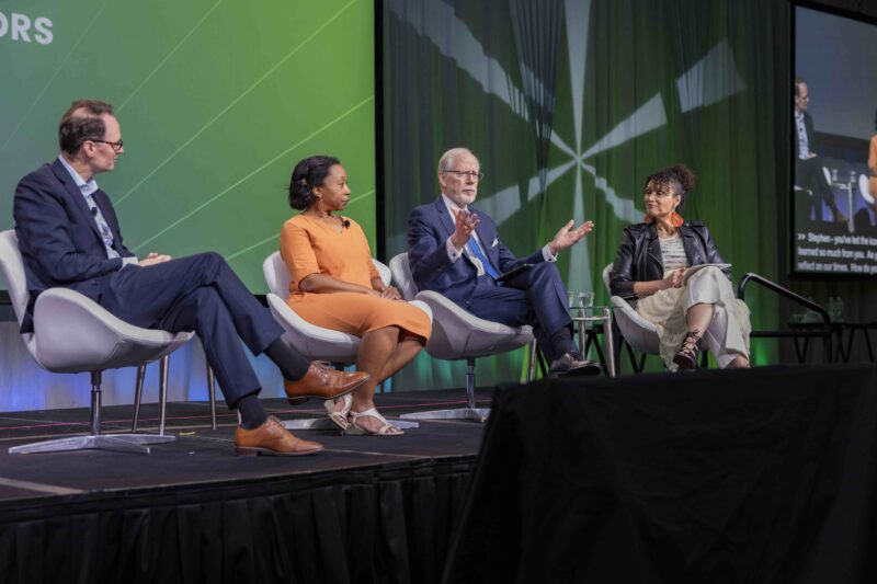 Four panelists on stage at conference